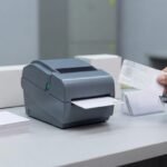 Desktop printer producing an employee badge with a visible watermark for hologram ID card printing